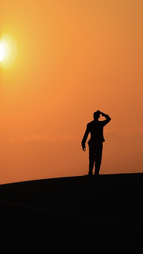 free-photo-of-silhouette-of-a-person-standing-on-a-hill-at-sunset.jpeg
